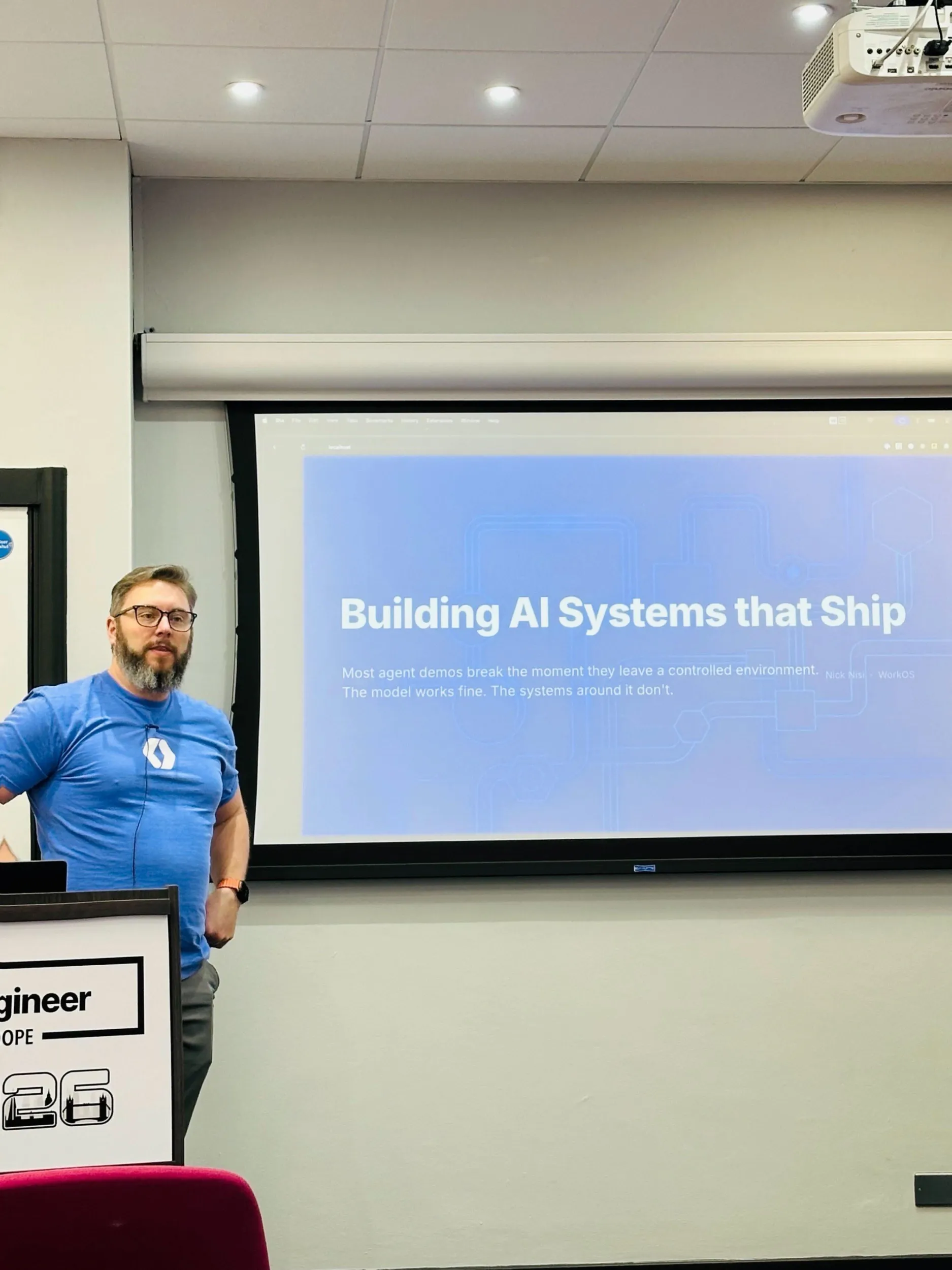 Nick next to the Building AI Systems that Ship title slide